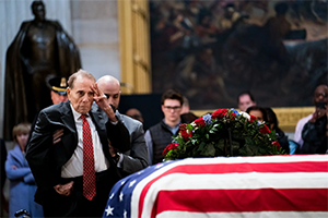 Bob Dole saluting George Bush casket